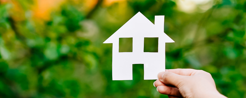 Image of person holding a paper cutout shaped like a house