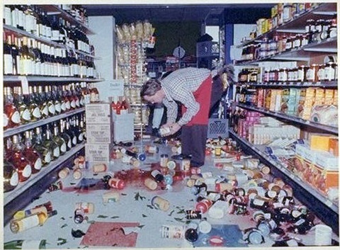 All American Market employee, Dell Ralls, cleans up after the 1989 earthquake. (Image by Joe Melena via Palo Alto Historical Association)