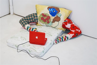 Beauty and the Binge, 2020, by Alezander Hernandez Single mattress and pillow with the face of Disney's Beauty, two stuffed tights that look like legs, and a small red Apple device