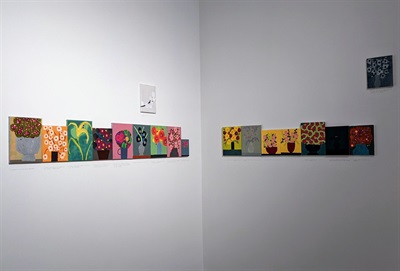 Flowers for Sick People, 2020-2021, by Tucker Nichols A row of small paintings of flowers in the corner of the gallery
