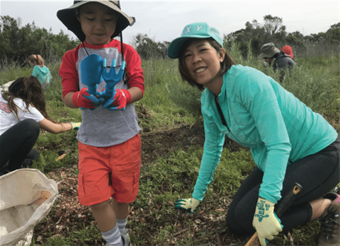 Volunteers planting are of a young child and woman