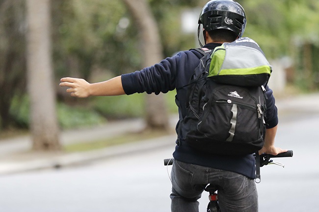 man on bike signaling with his arm