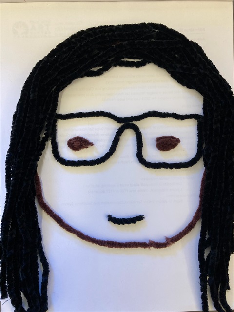 portrait in yarn of person with glasses and long black h
