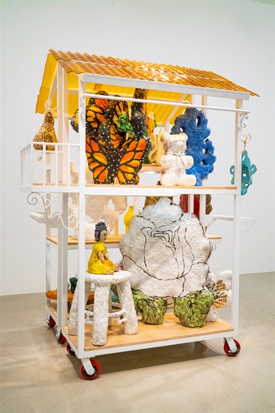 artwork featuring metal cart and ceramic artworks, including hearts