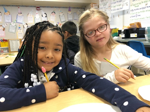 Two children sitting together as part of our Cultural Kaleidoscope program